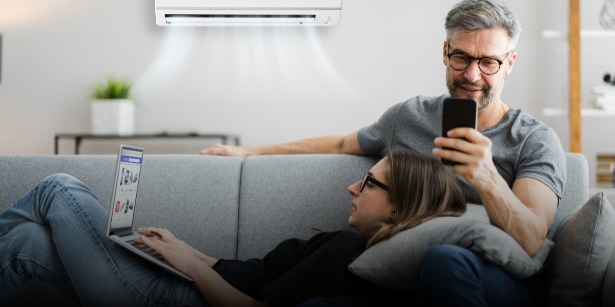 man and woman siting on couch in air-conditioned home